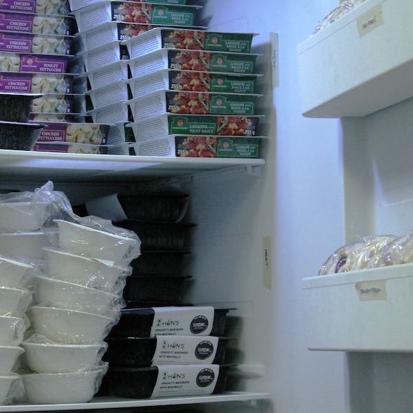 A full freezer in the WCk office showing a range of frozen meals stacked on the shelves