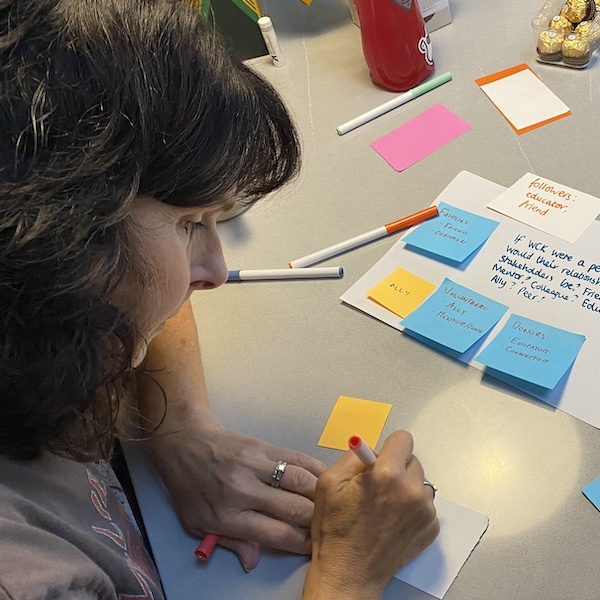 Leslie writing on a post-it note for a strategy activity