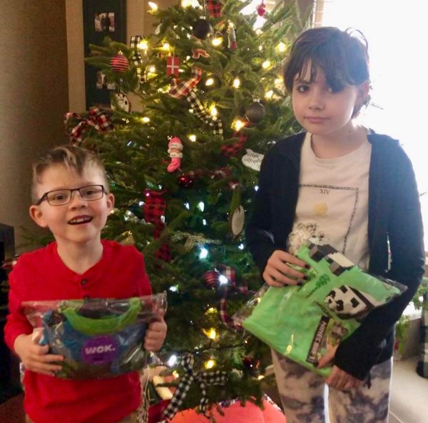 Nicole's kids, Emma and Ben, holding their PJ parcels
