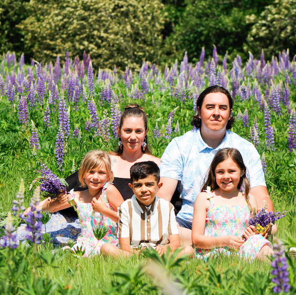 Ezra and his family are sitting in a field of lavender on a sunny day.